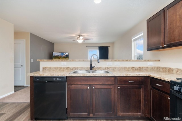 kitchen featuring black appliances, a sink, light countertops, and wood finished floors