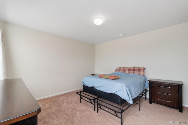 bedroom featuring light carpet and baseboards