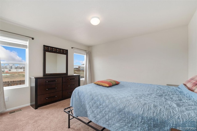 bedroom featuring light colored carpet and baseboards