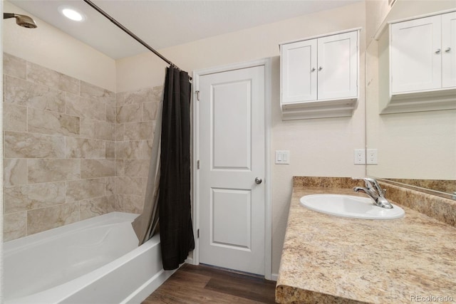 bathroom with shower / tub combo, wood finished floors, vanity, and recessed lighting
