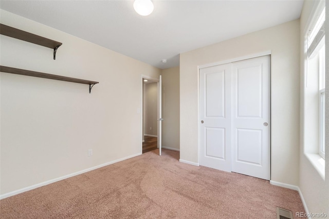 unfurnished bedroom featuring carpet flooring, baseboards, and a closet