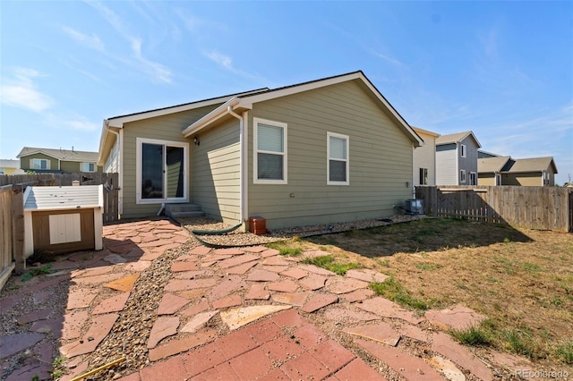 back of house with a fenced backyard, a patio, and central AC unit