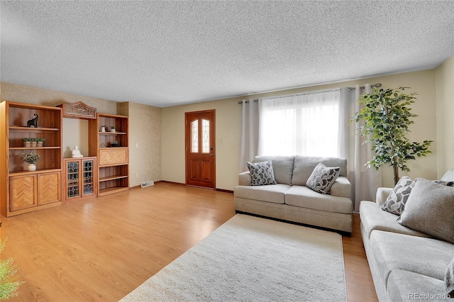 living room featuring wood-type flooring and a textured ceiling