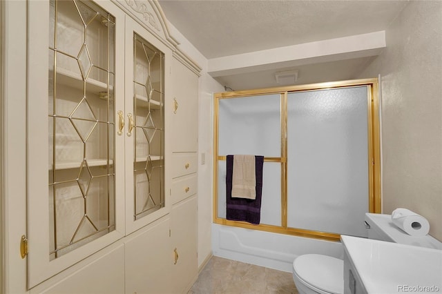 full bathroom featuring toilet, vanity, shower / bath combination with glass door, and a textured ceiling