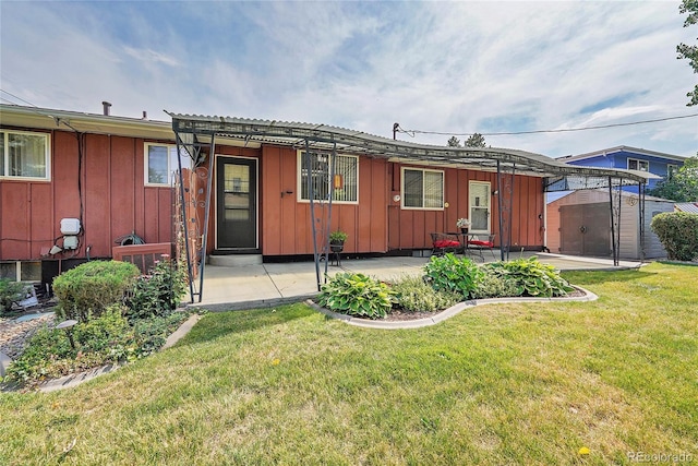 rear view of property with a patio and a lawn