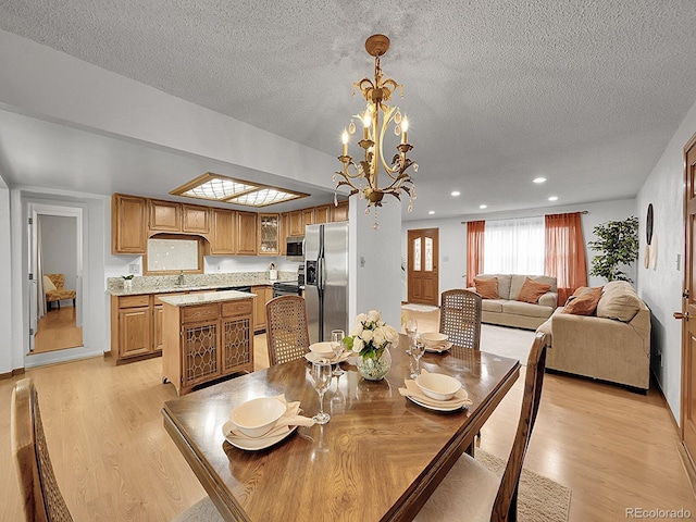 6769 W 70th Ave, Arvada, CO 80003 - dining room featuring a textured ceiling, light wood-style floors, a chandelier, and recessed lighting