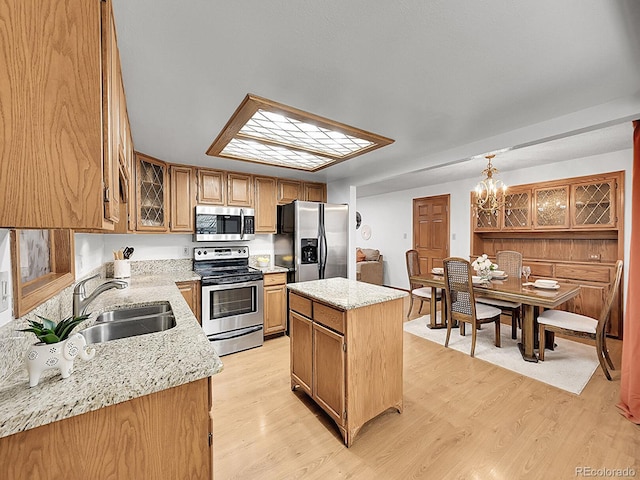 6769 W 70th Ave, Arvada, CO 80003 - kitchen featuring stainless steel appliances, a sink, a center island, a chandelier, and light wood-style floors