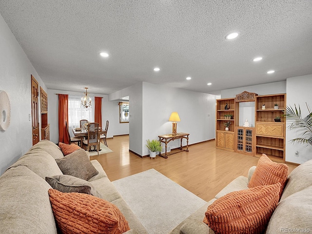 6769 W 70th Ave, Arvada, CO 80003 - living room with a textured ceiling, a chandelier, light wood-style flooring, recessed lighting, and baseboards
