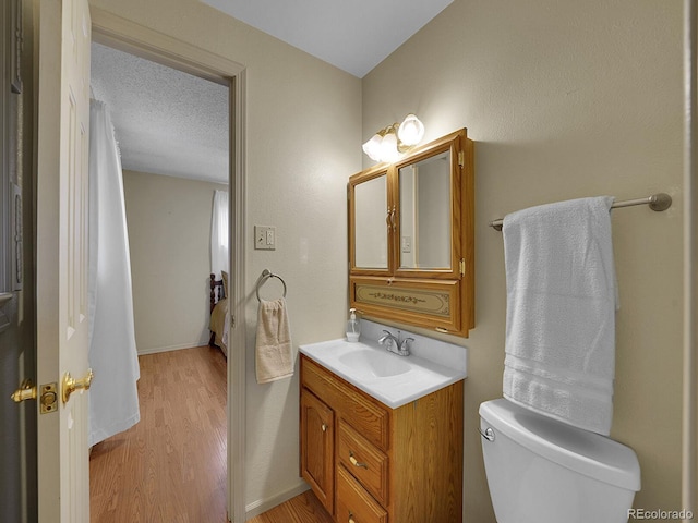 6769 W 70th Ave, Arvada, CO 80003 - bathroom featuring wood finished floors, toilet, and vanity