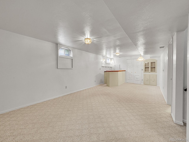 6769 W 70th Ave, Arvada, CO 80003 - below grade area featuring light carpet, baseboards, and a textured ceiling