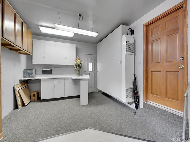 6769 W 70th Ave, Arvada, CO 80003 - kitchen featuring a heating unit, white cabinetry, carpet, and light countertops
