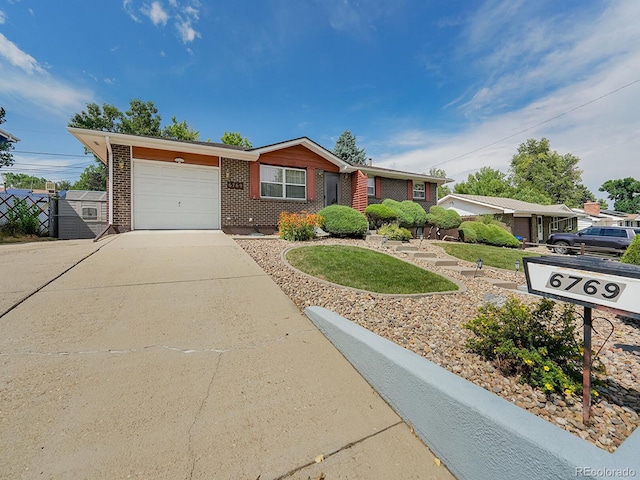 6769 W 70th Ave, Arvada, CO 80003 - ranch-style home featuring a garage, concrete driveway, and brick siding