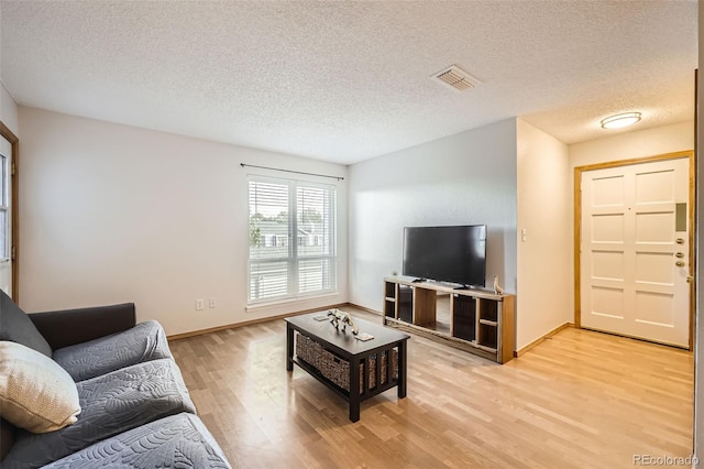 living room with light wood-type flooring and a textured ceiling