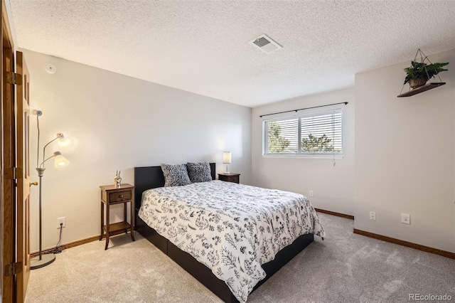 bedroom with light carpet and a textured ceiling