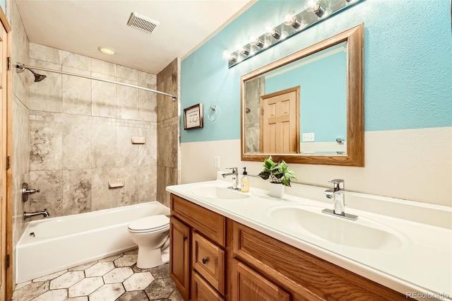 full bathroom featuring vanity, toilet, and tiled shower / bath