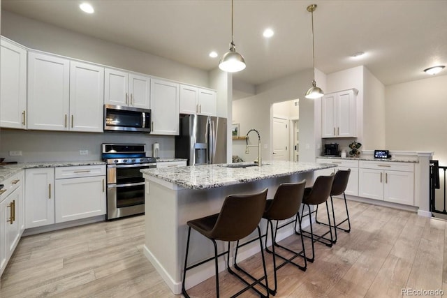 kitchen featuring white cabinetry, sink, a kitchen island with sink, and stainless steel appliances