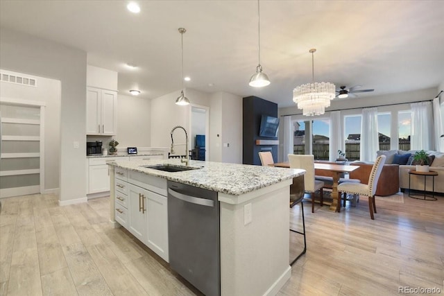 kitchen featuring pendant lighting, sink, white cabinets, a kitchen island with sink, and stainless steel dishwasher