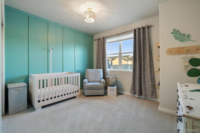 bedroom featuring light carpet and a nursery area