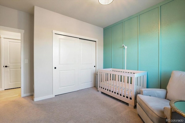 carpeted bedroom with a closet and a nursery area