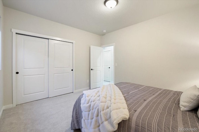 bedroom with light carpet and a closet