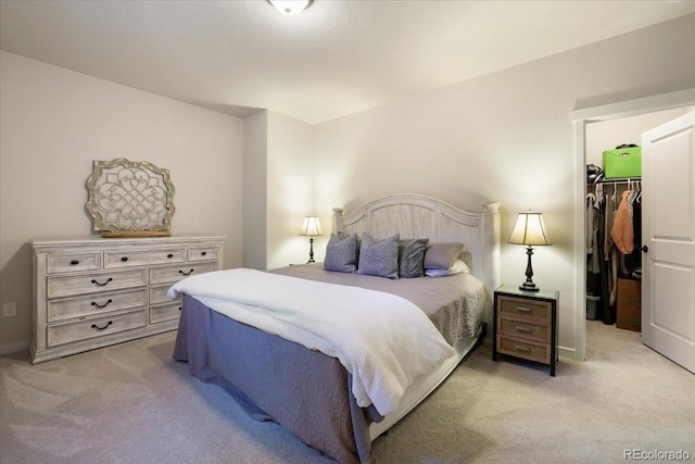 carpeted bedroom with a spacious closet and a closet