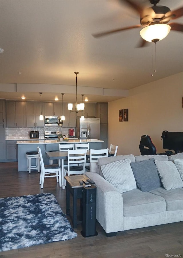 living room with a toaster, ceiling fan, and dark wood finished floors