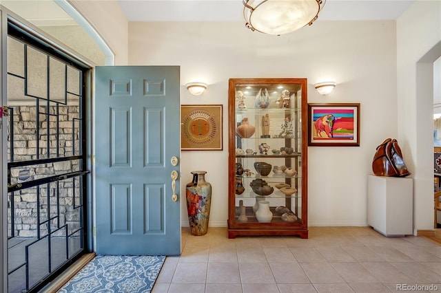 entrance foyer with baseboards and tile patterned floors