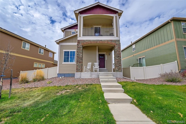 view of front facade with a balcony and a front lawn