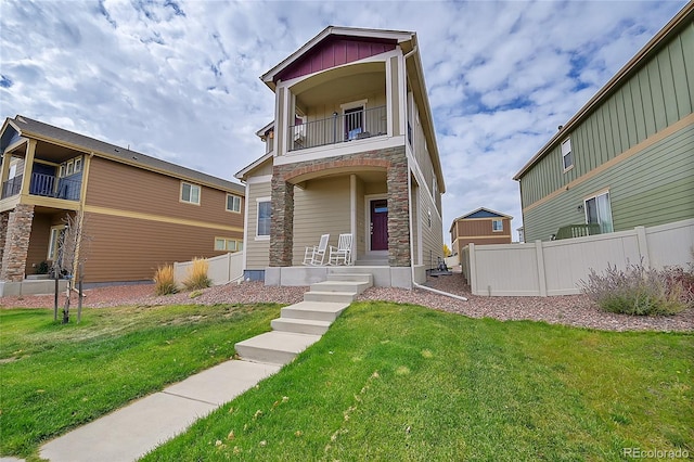 view of front of house with a balcony and a front yard