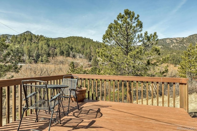 wooden terrace with a forest view and a mountain view