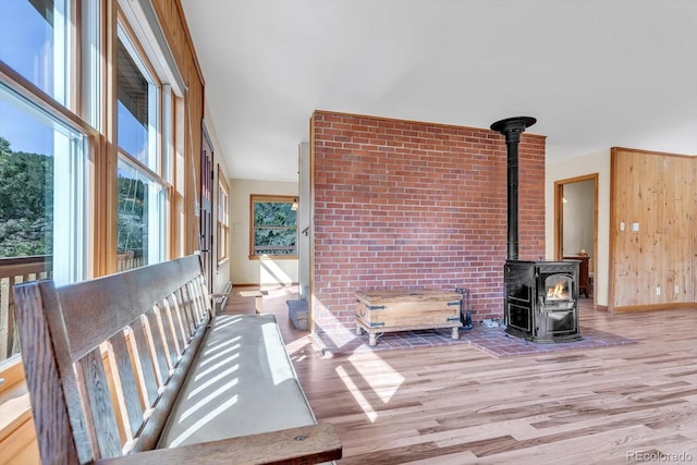 living area with a wood stove, baseboards, and wood finished floors