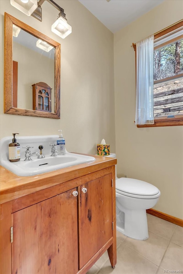 bathroom featuring baseboards, toilet, vanity, and tile patterned flooring