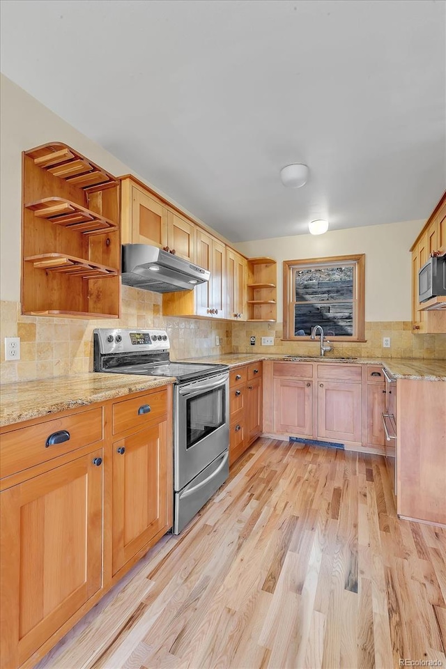 kitchen featuring light stone counters, open shelves, light wood-style flooring, appliances with stainless steel finishes, and under cabinet range hood