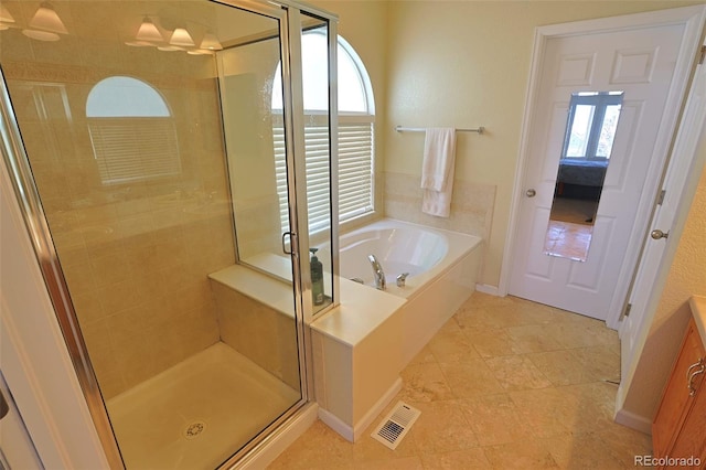 bathroom with a wealth of natural light, tile patterned floors, and separate shower and tub