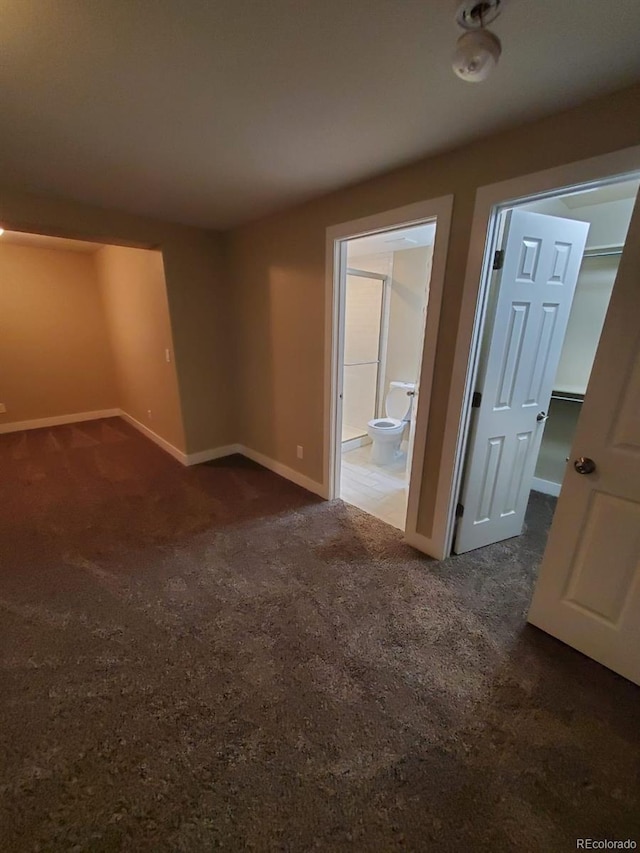 spare room with dark carpet