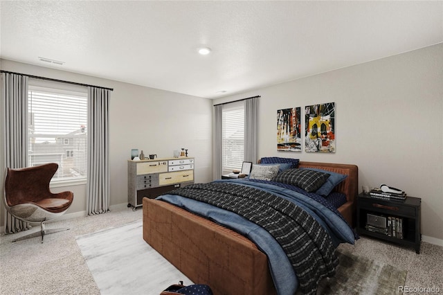 bedroom featuring a textured ceiling and light carpet