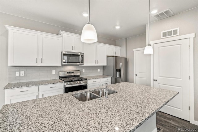 kitchen with white cabinets, sink, decorative light fixtures, dark hardwood / wood-style flooring, and stainless steel appliances