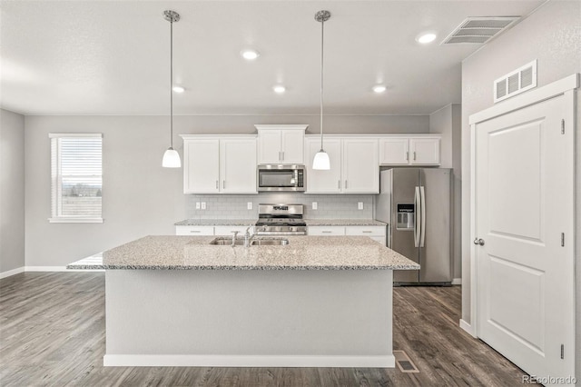 kitchen with pendant lighting, hardwood / wood-style flooring, white cabinets, and appliances with stainless steel finishes