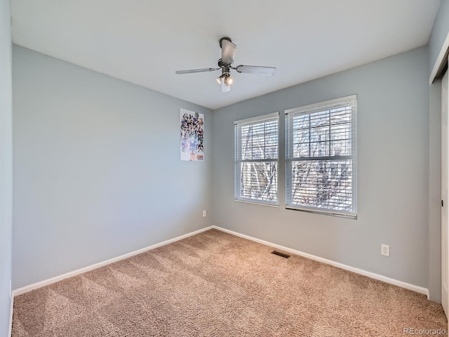 empty room featuring ceiling fan and carpet floors