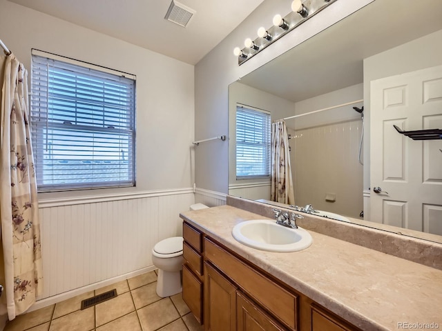 bathroom with tile patterned floors, plenty of natural light, vanity, and toilet