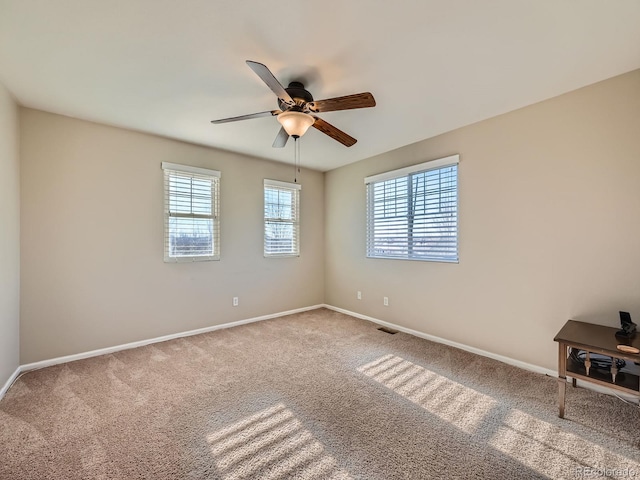 empty room featuring carpet floors, a wealth of natural light, and ceiling fan