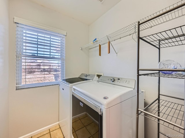 clothes washing area featuring washing machine and clothes dryer and light tile patterned floors