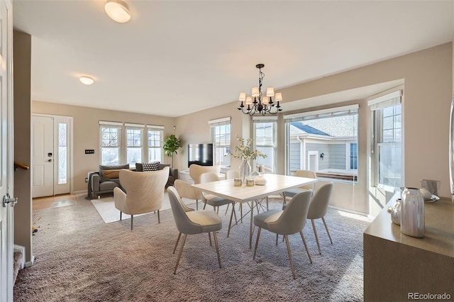 carpeted dining room with a chandelier