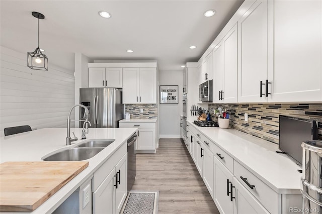 16486 W 94th Dr, Arvada, CO 80007 - kitchen with stainless steel appliances, recessed lighting, tasteful backsplash, hanging light fixtures, and white cabinetry