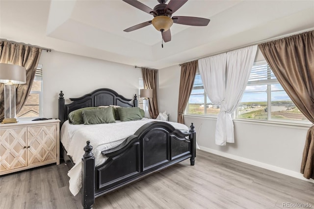 16486 W 94th Dr, Arvada, CO 80007 - bedroom featuring a tray ceiling, wood finished floors, and ceiling fan