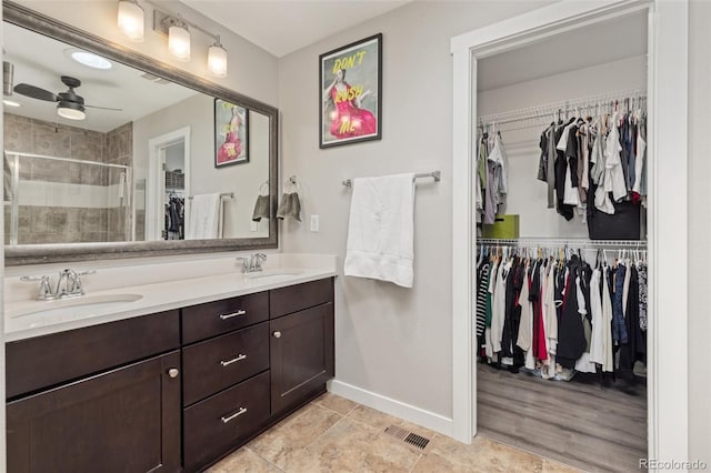 16486 W 94th Dr, Arvada, CO 80007 - bathroom with double vanity, a spacious closet, a stall shower, a ceiling fan, and tile patterned floors