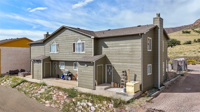2480 Allegheny Dr, Colorado Springs, CO 80919 - rear view of property featuring a shed, a chimney, a patio area, and a mountain view