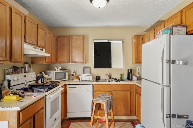 2480 Allegheny Dr, Colorado Springs, CO 80919 - kitchen with white appliances, under cabinet range hood, light countertops, and a textured ceiling