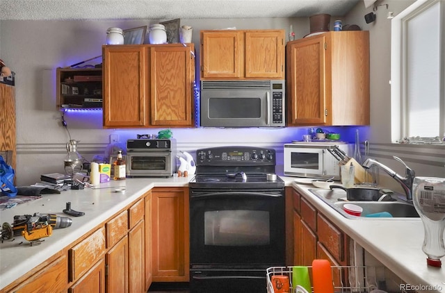 2480 Allegheny Dr, Colorado Springs, CO 80919 - kitchen featuring stainless steel microwave, black electric range oven, light countertops, and brown cabinets