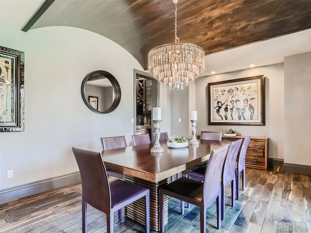 dining room featuring hardwood / wood-style flooring, brick ceiling, lofted ceiling, and an inviting chandelier